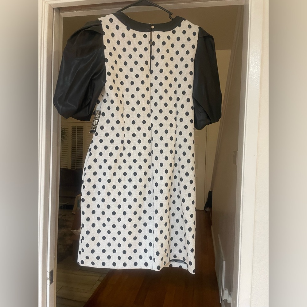 New with tags. Black & white polka dot dress w/faux leather sleeves and collar.